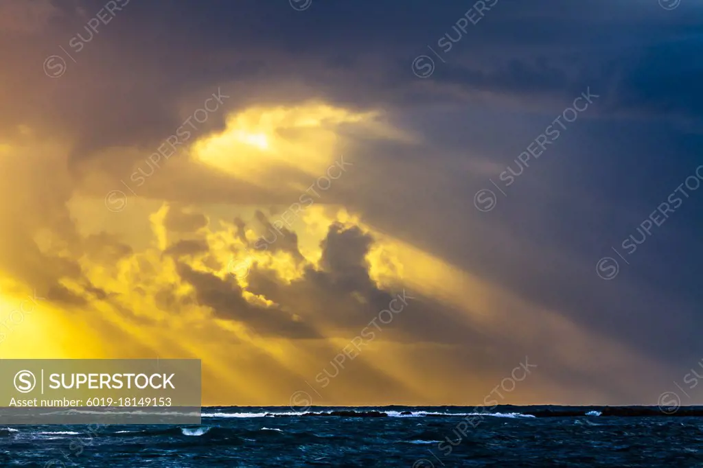 Sun rays from the sky over the sea at sunset