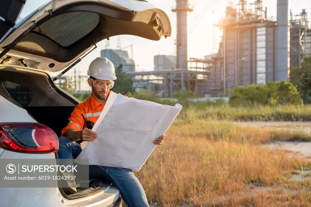 Refinery industry engineer with blueprint working at outdoor