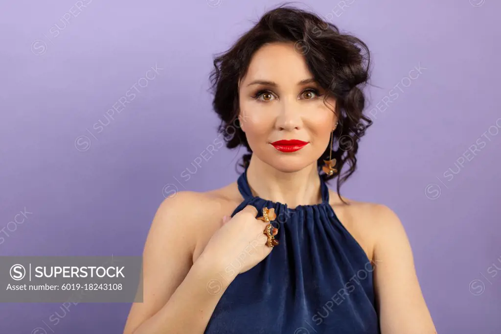 young happy woman in a blue dress on a lilac background