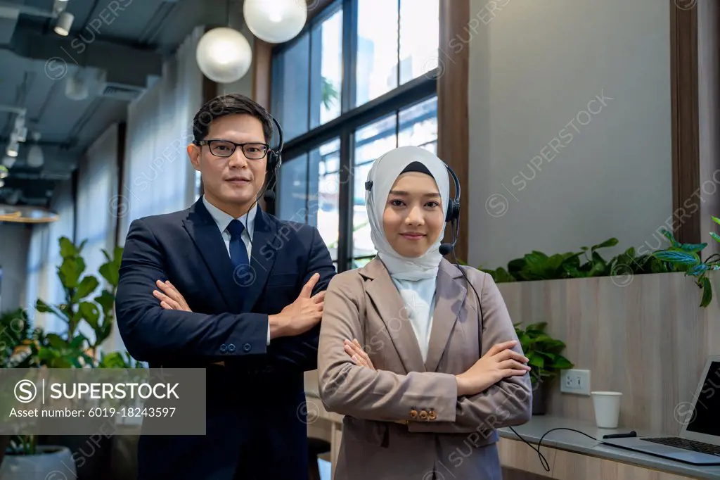 Portrait of businessman and Muslim lady employee standing