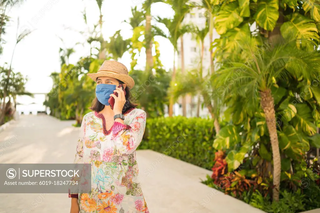Young smiling woman talking on the phone in the backyard of her house.