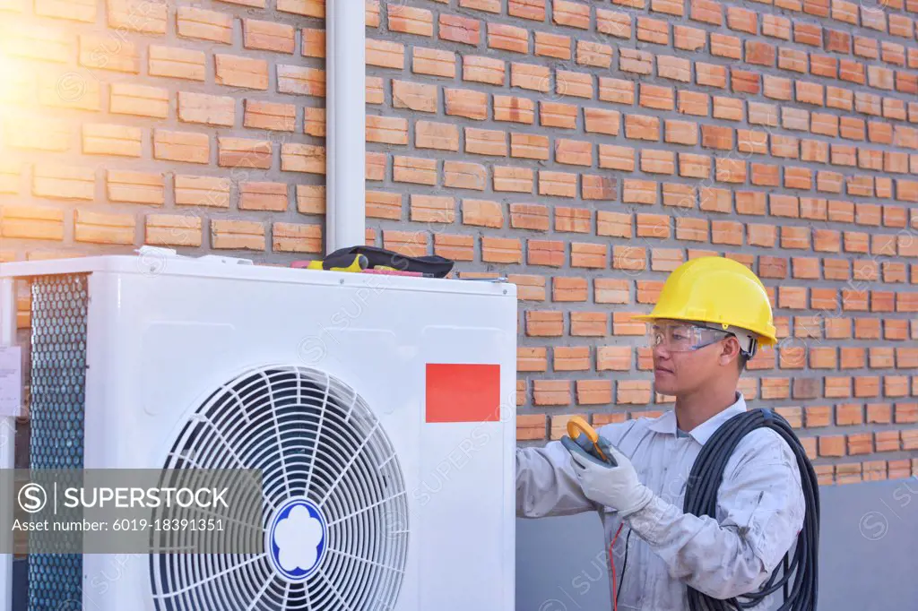 Air conditioner repairmen work on home unit.