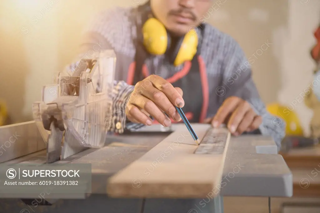 Carpenter working with equipment on wooden table in carpentry s