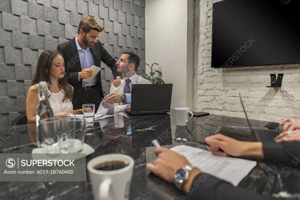 Handsome manager reviewing his peers on a meeting conference room