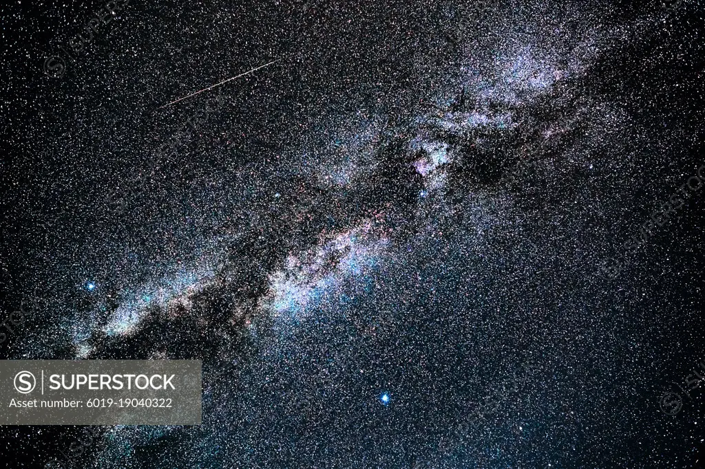 A shooting star steaks the sky next to the Milky Way