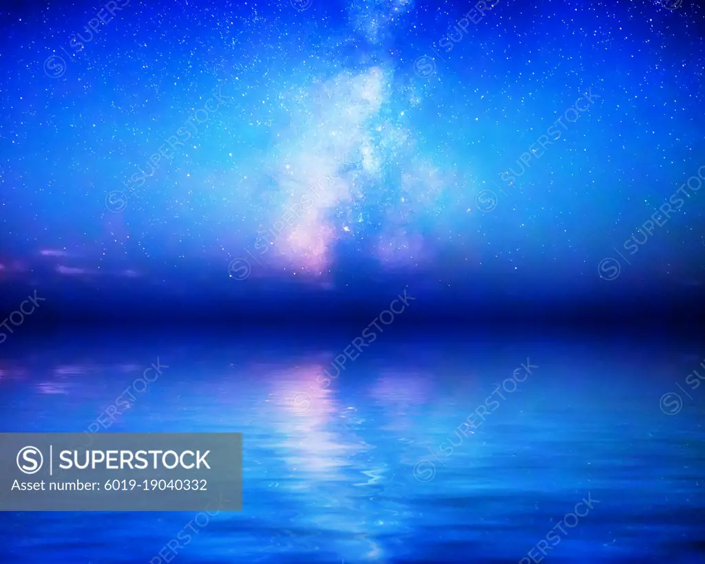 The Milky Way rises above milky blue calm waters