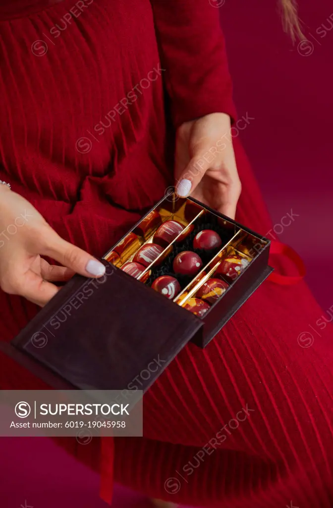 Woman holding opened box with bonbons