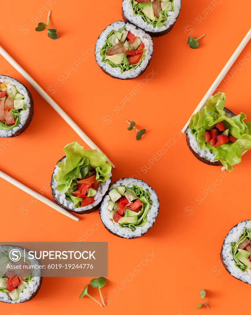 vegan vegetables sushi and rolls on orange background