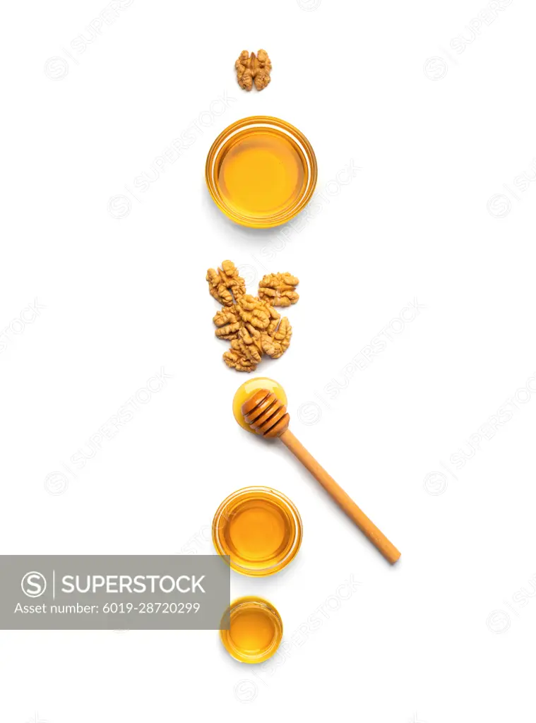 Honey in jars, dipper and nuts on a white background top view.
