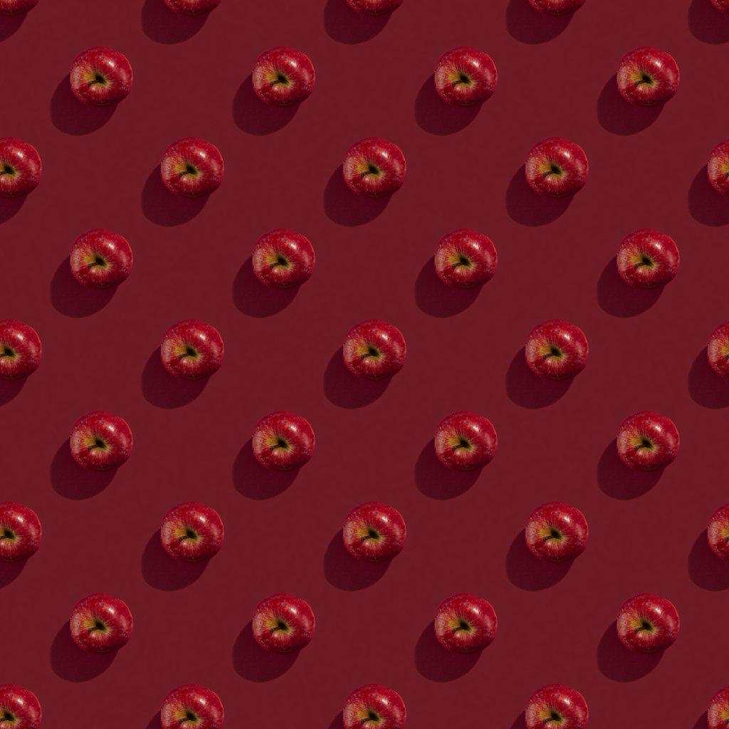 red apple on red background seamless pattern