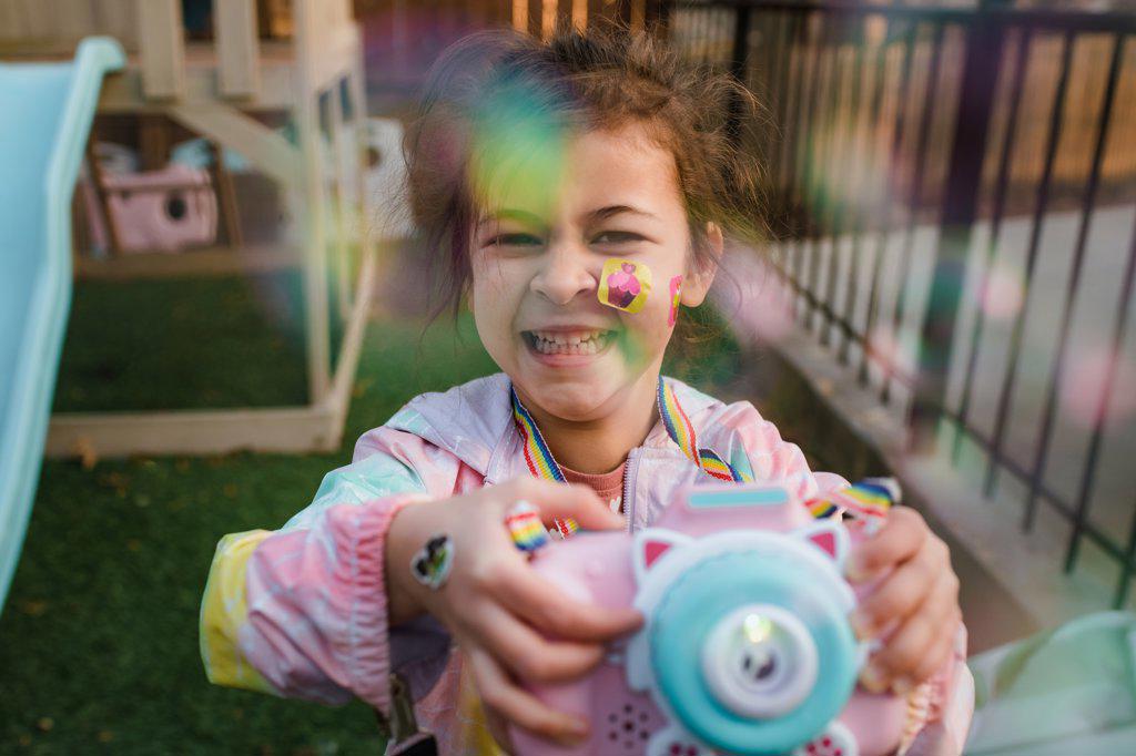 Smiling girl playing with bubbles in back yard