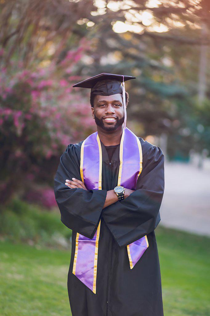 Young man graduating college, wearing a graduation gown/cap