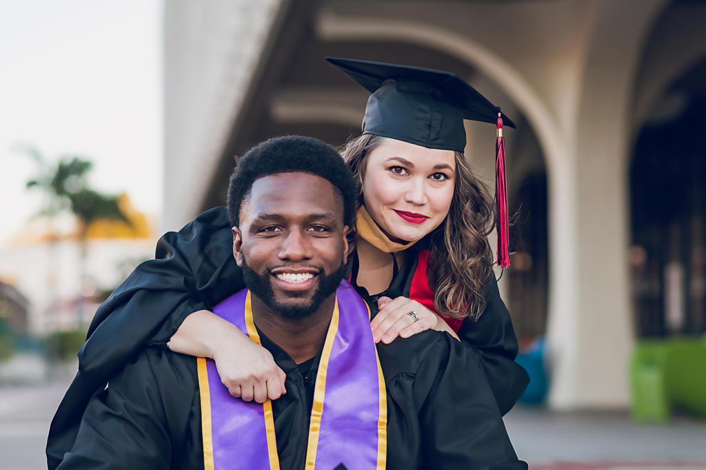 Young man & woman graduating college, wearing a graduation gown/cap.