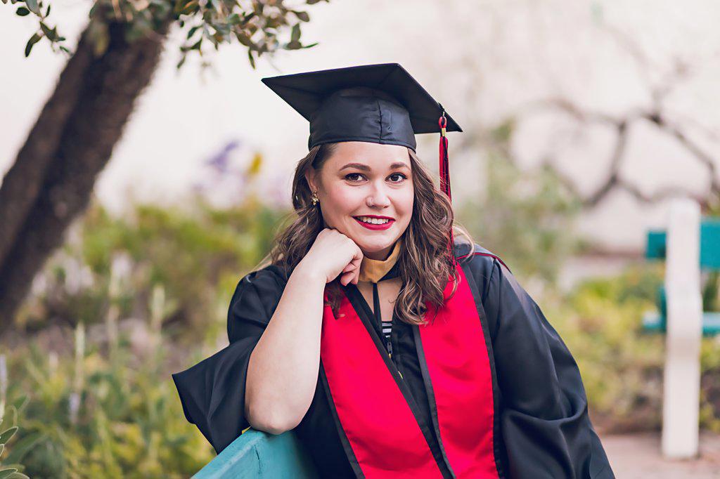 Young woman wearing a graduation gown/cap.