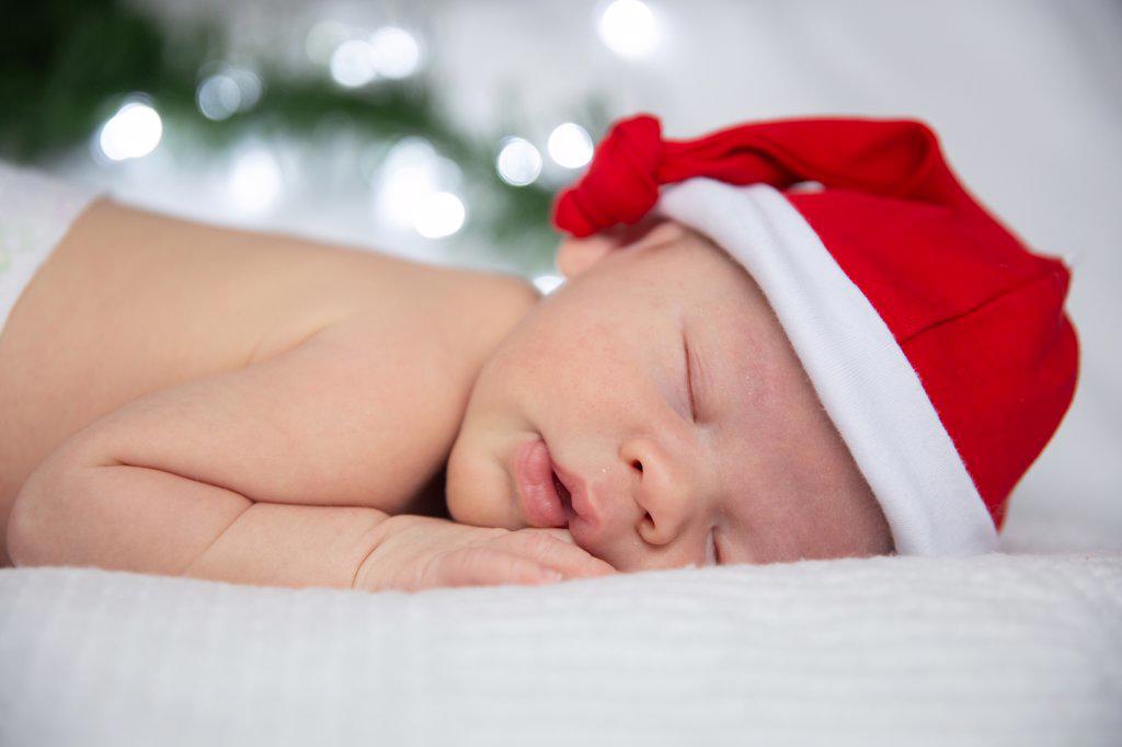 sleeping baby in santa claus cap