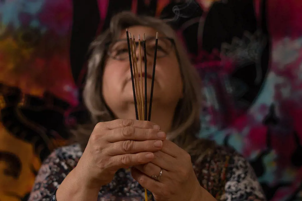 woman holding burning incense in her hands in meditation
