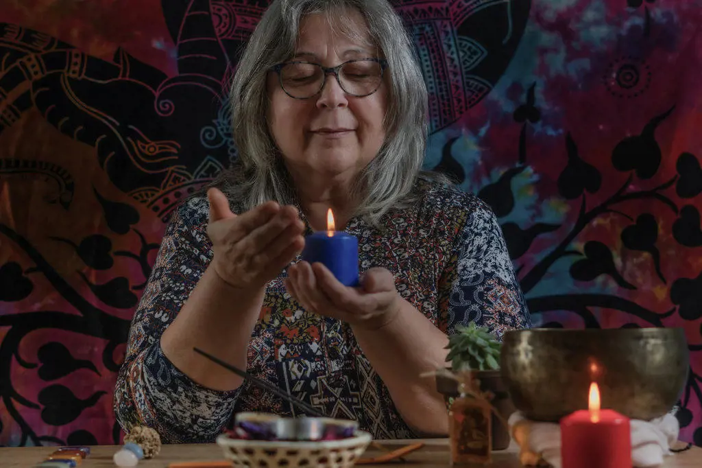 older woman looking at a lighted candle