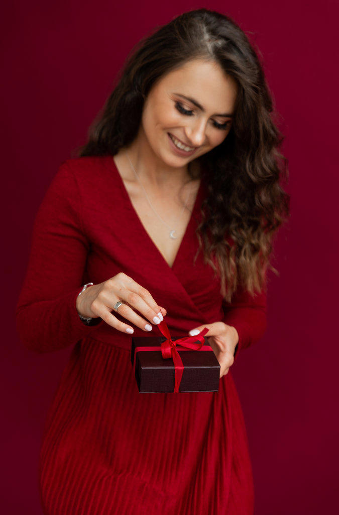 Positivity emotional woman in red dress opened box with stripe