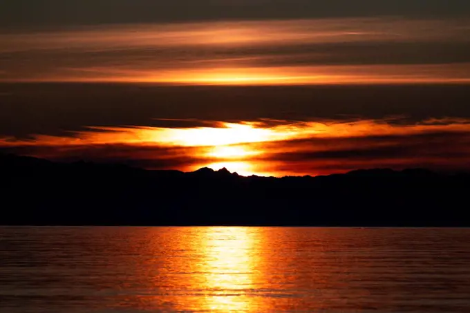 A silhouette of Olympic National Park at sunset from Whidbey Island
