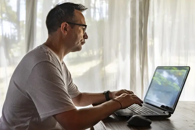 A man working at home, using a laptop