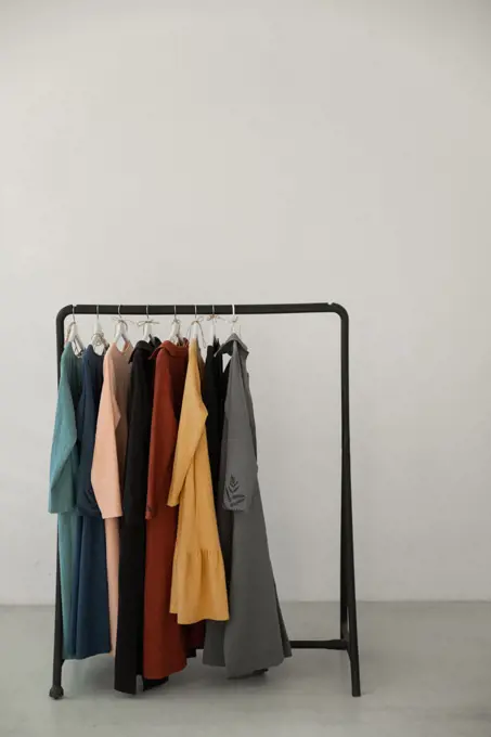 Black minimalistic rack with eco linen clothes on white backgrou