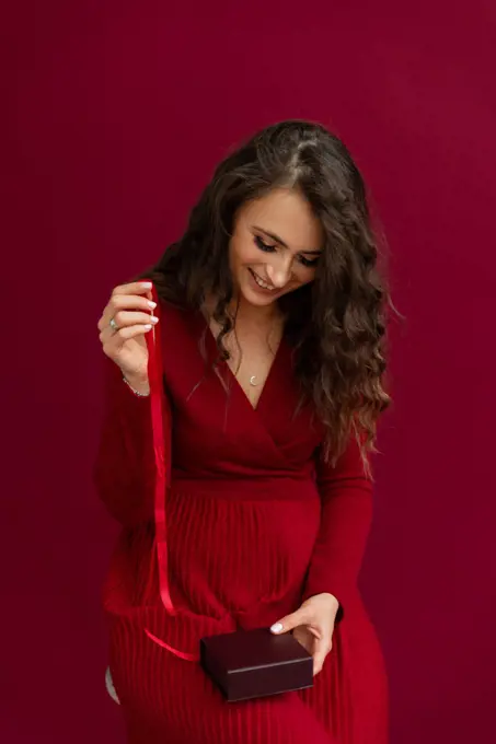 Smiling woman in red opened box with present