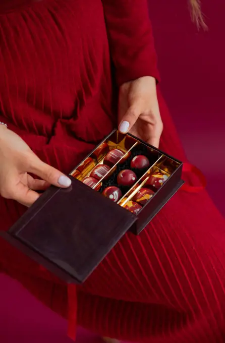 Woman holding opened box with bonbons