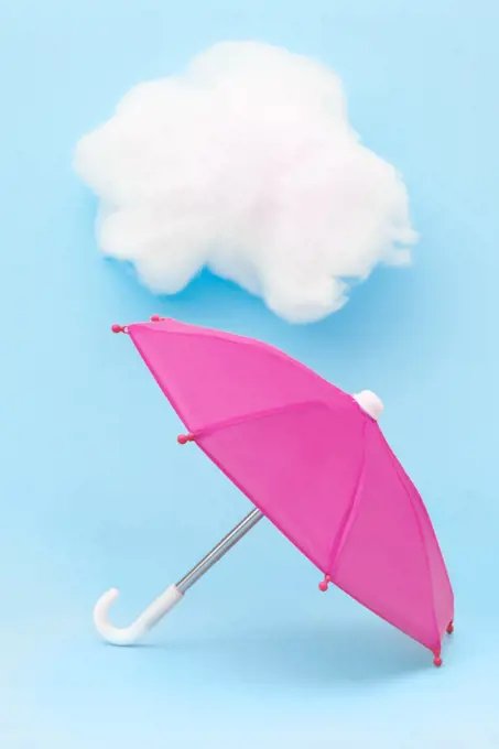 Pink Umbrella on Blue Background with White cloud spring rain