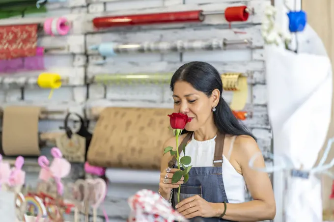 woman in her flower shop with a beautiful flower