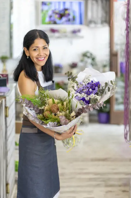 woman in her florist business preparing some bouquets of flowers