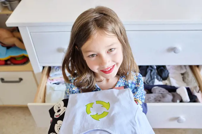 7-year-old girl preparing clothes to reuse and deliver.