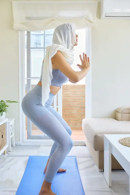 arab young woman doing sports at home with hijab