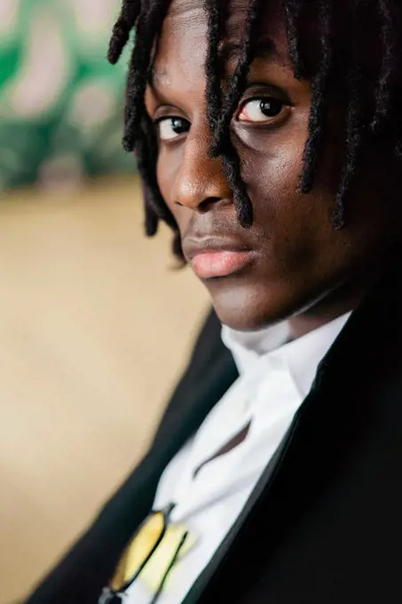 Black man with dreadlocks wearing a suit and glasses