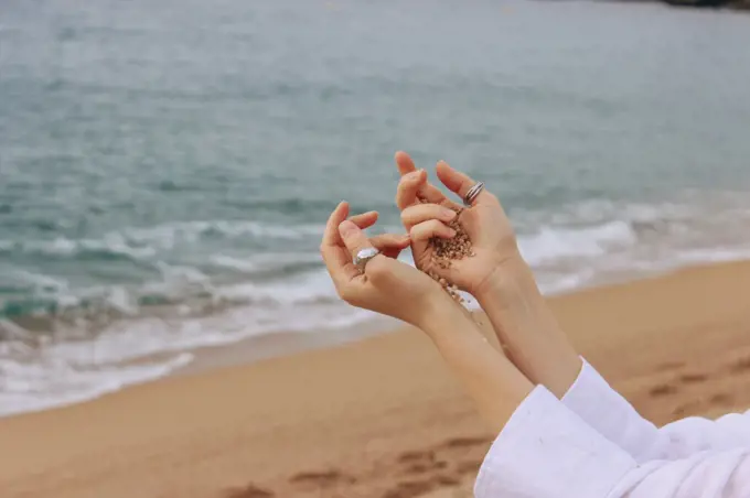Girl hands on the background of beach and sea