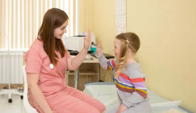 4 year old patient joyfully high fives to the nurse