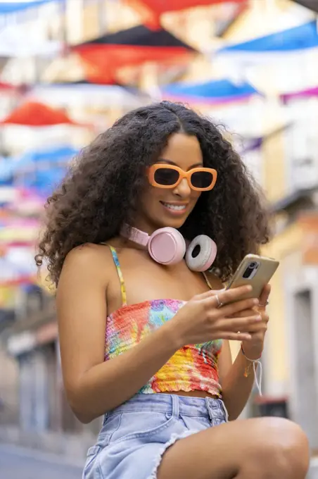 girl with afro hair using her smartphone