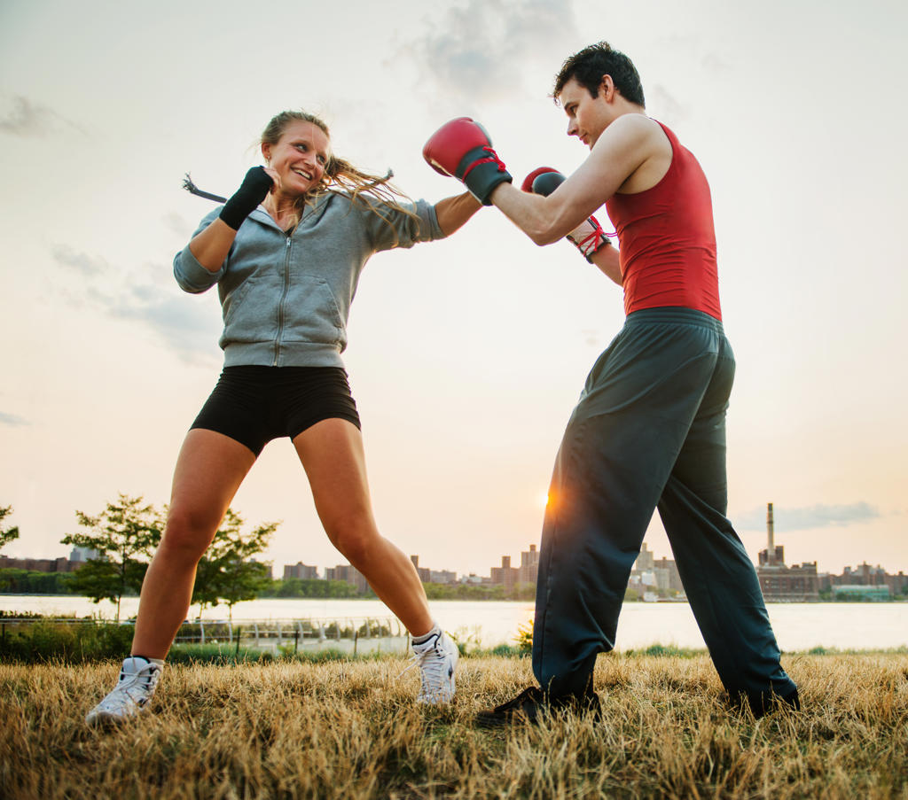 man and woman boxing, training in the park	