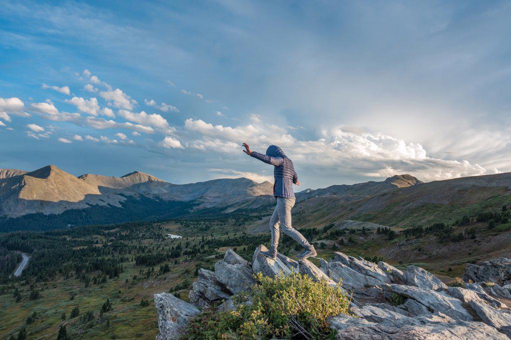 Woman hiking along rock formation ridge in  Colorado Alpine