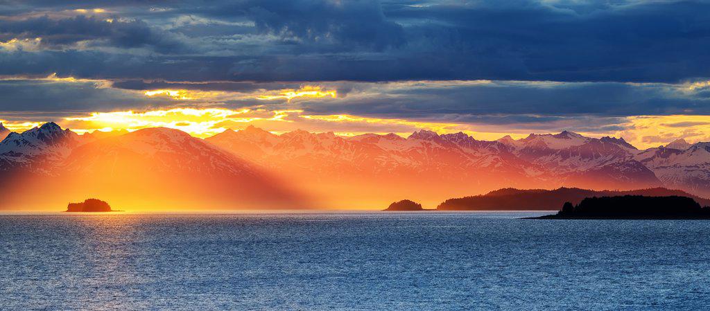 Orange Gold Light and dramatic cloudbursts over the Chilkat Range and Lynn Canal in Alaska 
