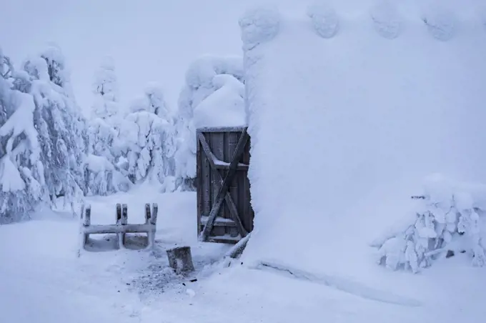 View of a wood shed covered in snow after a blizzard in the Finnish Lapland wilderness. Chocolate Box Winter Scene
