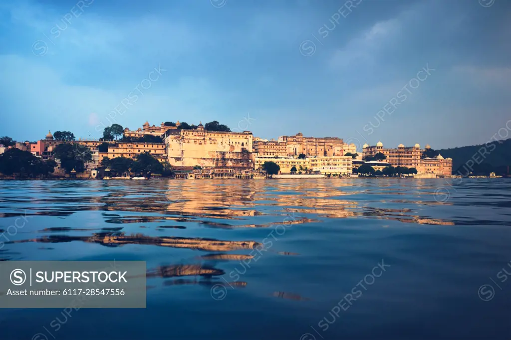 View of famous romantic luxury Rajasthan indian tourist landmark - Udaipur  City Palace on sunset with cloudy sky - surface level view. Udaipur,  Rajasthan, India - SuperStock