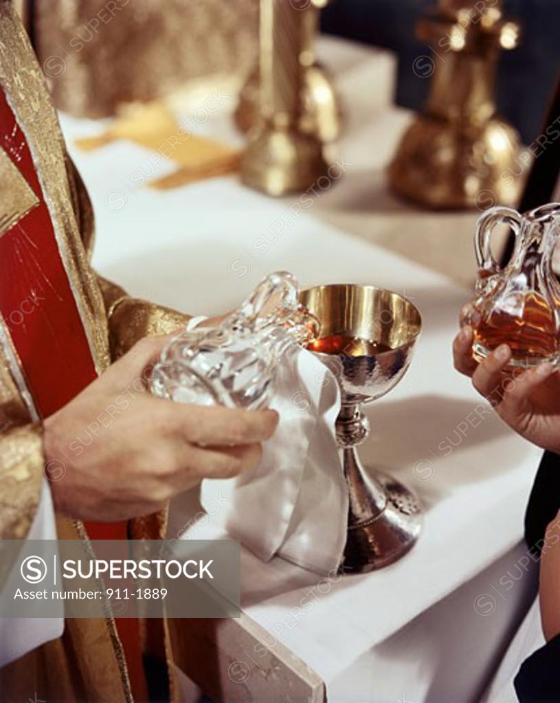 Stock Photo: 911-1889 Priest pouring communion wine into a chalice