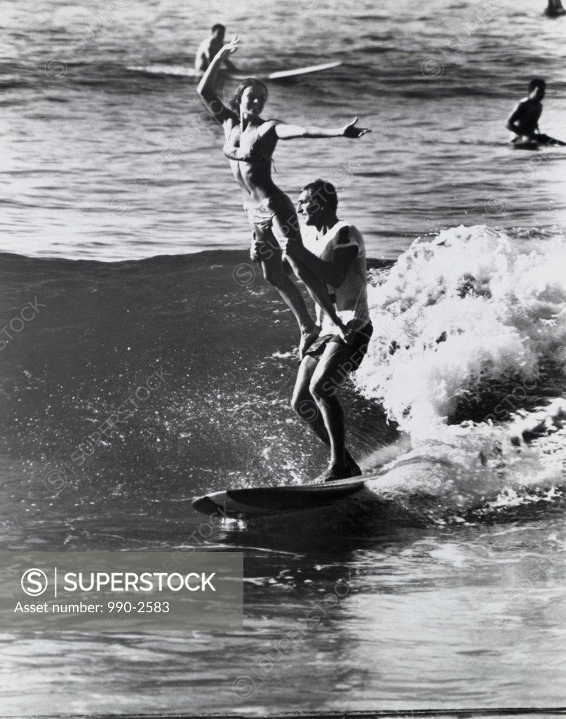 Stock Photo: 990-2583 Young couple surfing in the sea