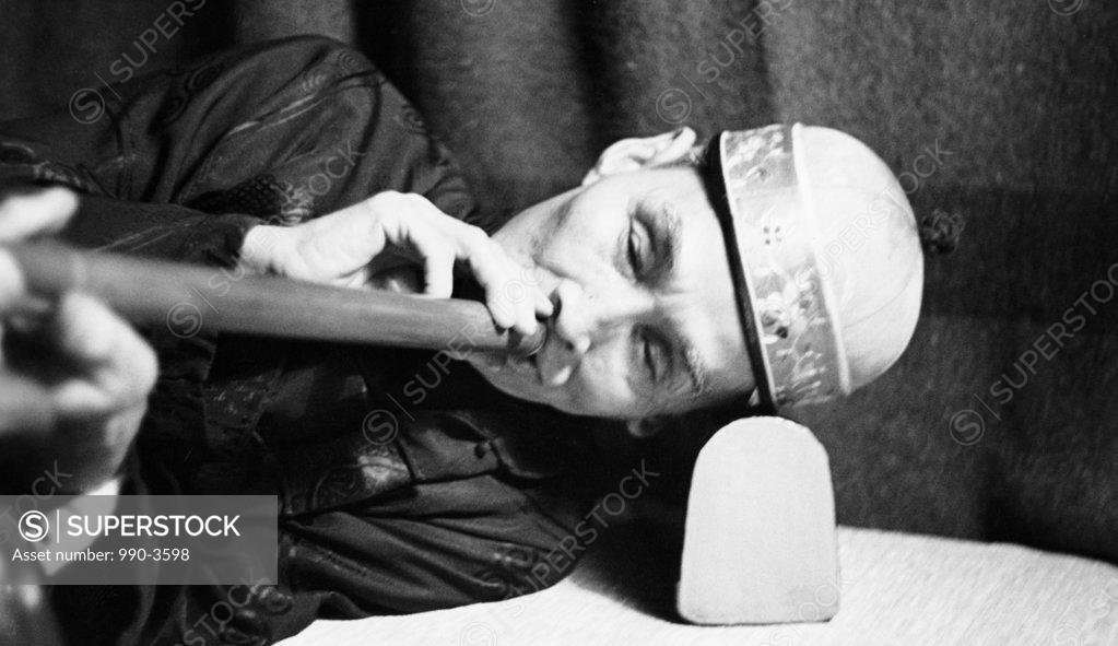 Stock Photo: 990-3598 Close-up of a mature man smoking opium