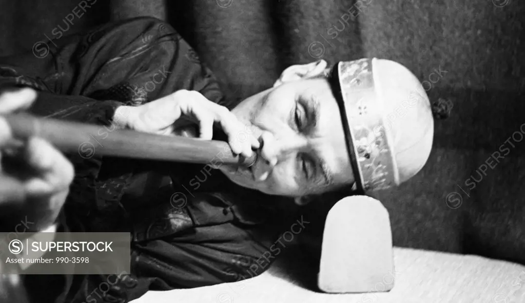 Close-up of a mature man smoking opium