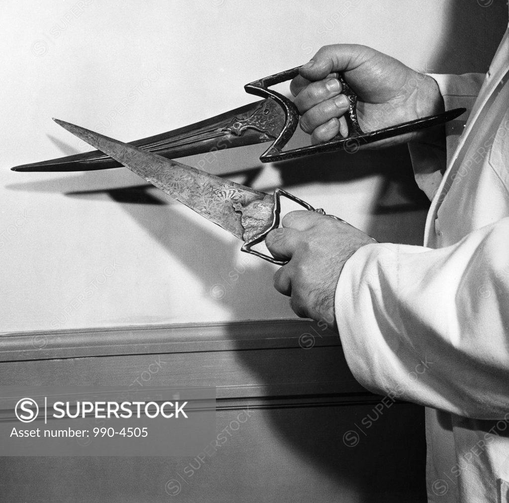 Stock Photo: 990-4505 Mid section view of a man holding Indian Thrusting Daggers